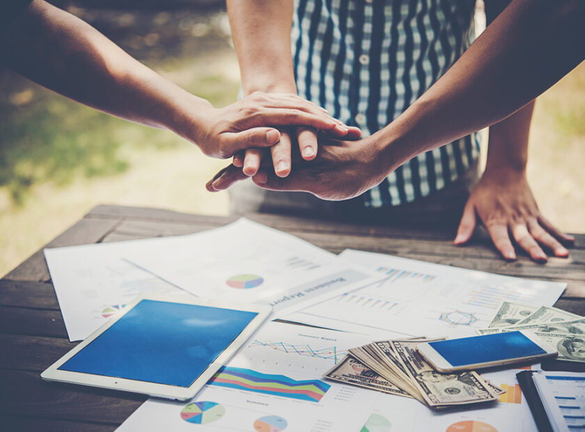 Business people making pile of hands. Teamwork concept.